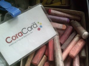 CoraCora business card on top of oil pastels